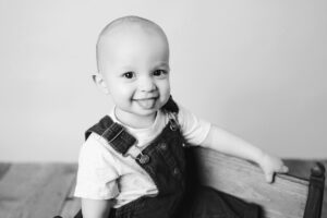 black and white photo of a baby boy making a funny face