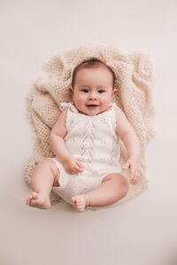 baby girl on her back smiling