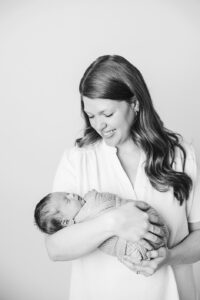 mom smiling down at newborn baby in black and white, raleigh newborn photographer