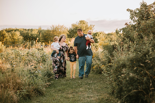 cary family photographer, family walking through field