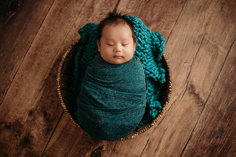 2 month old swaddled baby in basket teal raleigh