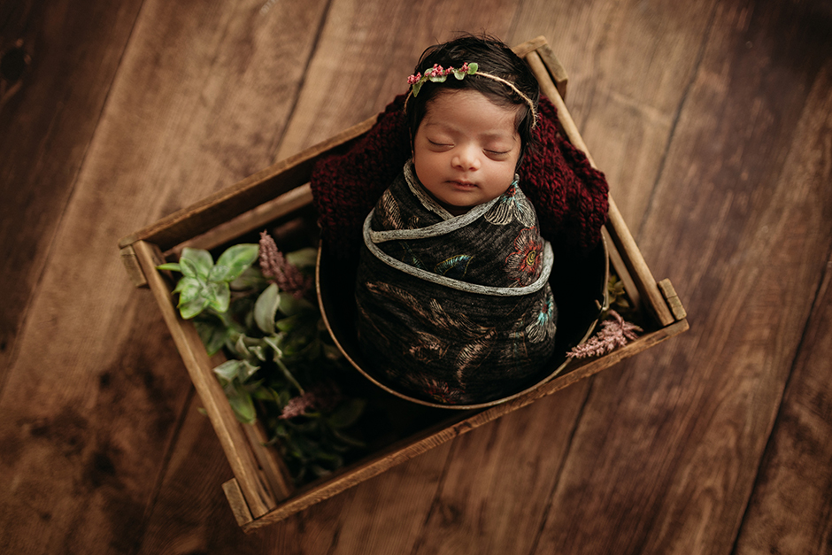 swaddled newborn in crate raleigh