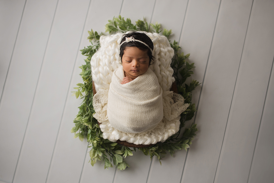 swaddled newborn photo with greenery raleigh