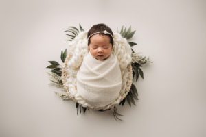 simple swaddled baby with greenery Cary NC