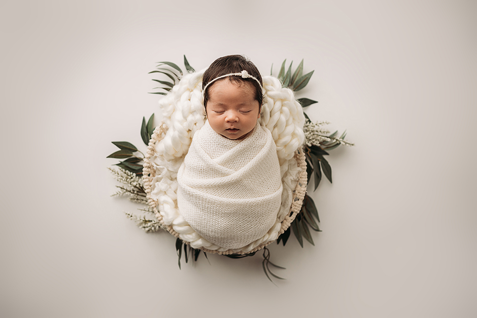 simple swaddled baby with greenery Cary NC