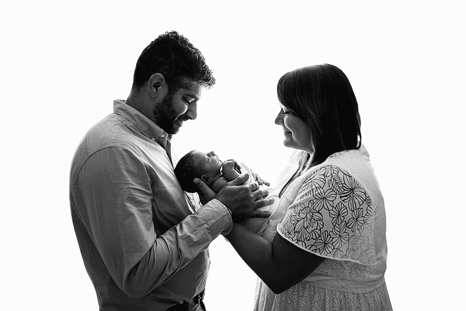 mom and dad holding baby backlit, cary nc newborn photographer