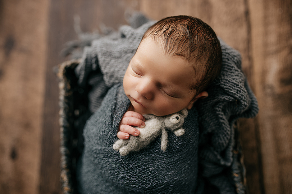 swaddled baby holding teddy bear in Cary nc