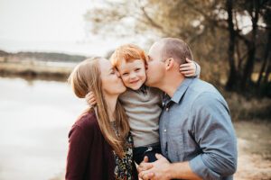 mom and dad kissing son raleigh family photographer