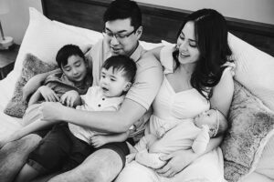 family on bed newborn lifestyle