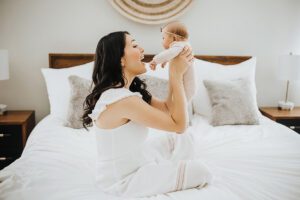 mom playing with baby on bed apex nc