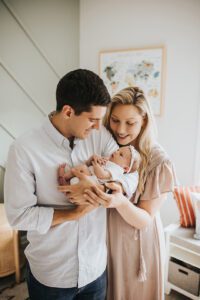 parents holding newborn baby in nursery, lifestyle baby photos clayton