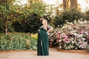 pregnant mother in green dress in azalea garden raleigh maternity pictures