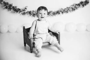 cary baby photographer Laura Karoline phography, baby sitting and smiling in black and white
