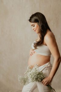 soft pregnancy photo with baby's breath flowers, modern maternity photos, studio maternity photos raleigh