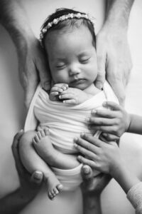 baby with family members hands, black and white, cary newborn photo studio Laura Karoline Photography