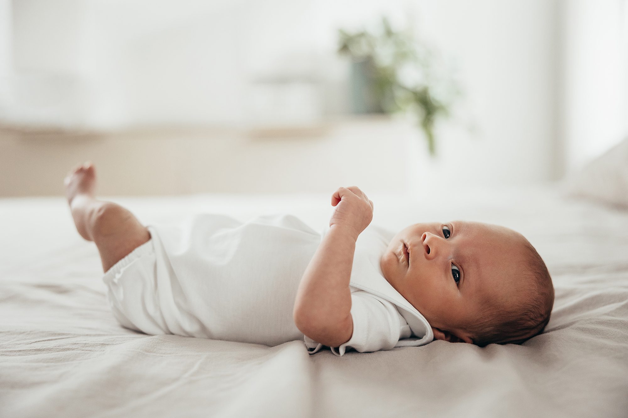 awake newborn on bed, in-home newborn photographer in raleigh