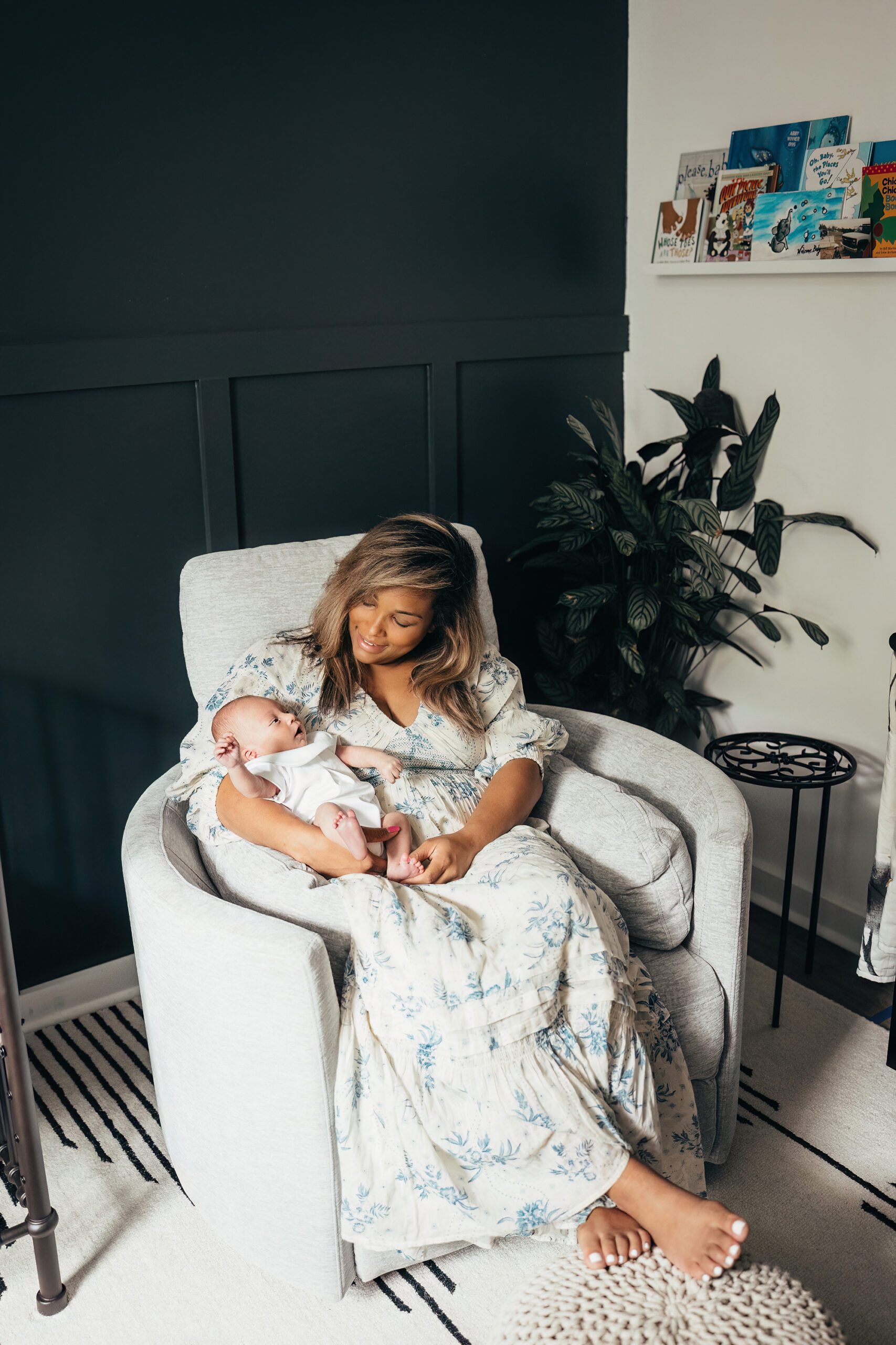 mom rocking with newborn in nursery, lifestyle newborn photography in raleigh